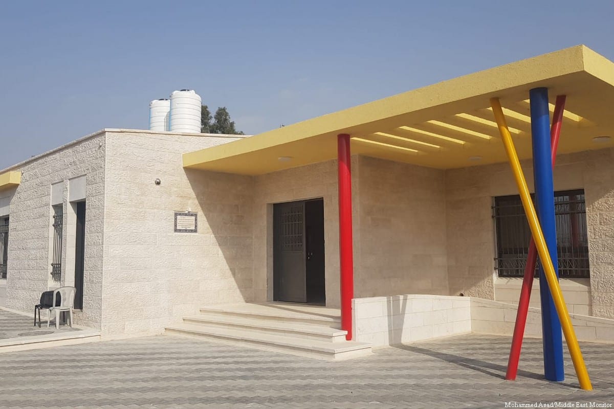 A new stone kindergarten with a yellow canopy on red, blue and yellow pillars